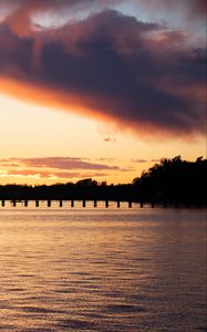 Preview wallpaper sea, pier, pilings, trees, evening, silhouettes