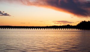 Preview wallpaper sea, pier, pilings, trees, evening, silhouettes