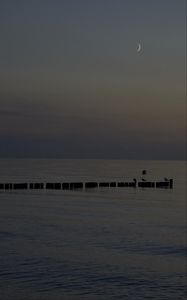 Preview wallpaper sea, pilings, night, moon, sky