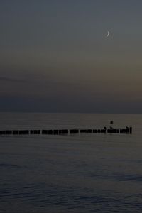 Preview wallpaper sea, pilings, night, moon, sky