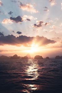 Preview wallpaper sea, rays, sun, rocks, sunset