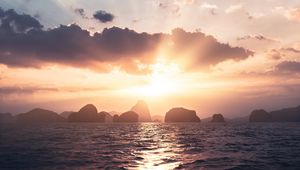 Preview wallpaper sea, rays, sun, rocks, sunset
