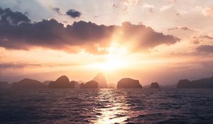 Preview wallpaper sea, rays, sun, rocks, sunset