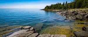 Preview wallpaper sea, ripples, water, stones, trees, nature