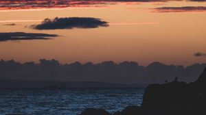 Preview wallpaper sea, rocks, dusk, horizon, clouds