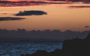 Preview wallpaper sea, rocks, dusk, horizon, clouds