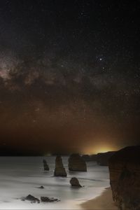 Preview wallpaper sea, rocks, stars, starry sky, dark