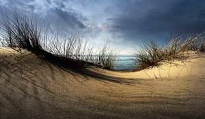 Preview wallpaper sea, sand, grass, hill, cloudy, coast, hollow