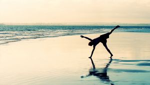 Preview wallpaper sea, shore, silhouette, water, sky, jump