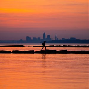 Preview wallpaper sea, silhouettes, pier, city, dark