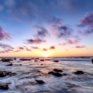 Preview wallpaper sea, stones, horizon, sunset, clouds, nature