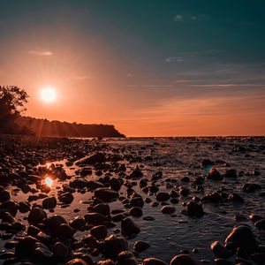 Preview wallpaper sea, sunset, stones, shore, light