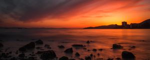 Preview wallpaper sea, sunset, stones, horizon, sky, coast