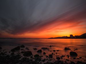 Preview wallpaper sea, sunset, stones, horizon, sky, coast