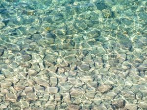 Preview wallpaper sea, water, bottom, stones, pebbles, glare