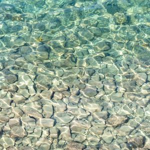 Preview wallpaper sea, water, bottom, stones, pebbles, glare