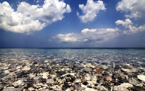 Preview wallpaper sea, water, transparent, stones, bottom, clouds, sky