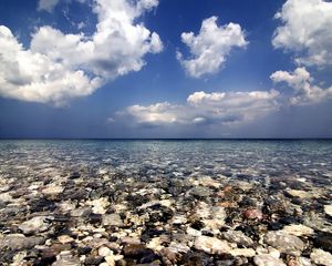 Preview wallpaper sea, water, transparent, stones, bottom, clouds, sky