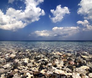 Preview wallpaper sea, water, transparent, stones, bottom, clouds, sky