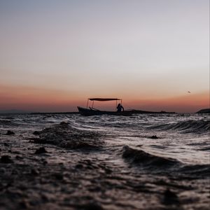 Preview wallpaper sea, waves, boat, silhouette, dark, dusk