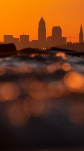 Preview wallpaper sea, waves, city, silhouettes, sunset