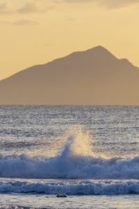 Preview wallpaper sea, waves, splashes, mountain, silhouette, landscape