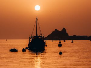 Preview wallpaper ship, sunset, glare, silhouette, sea
