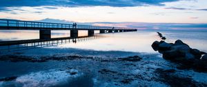 Preview wallpaper shore, bridge, silhouettes, sea, water, twilight