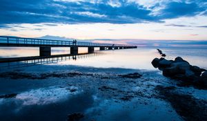 Preview wallpaper shore, bridge, silhouettes, sea, water, twilight