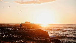 Preview wallpaper shore, sea, sunset, silhouettes, clouds, surf