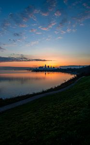 Preview wallpaper shore, water, horizon, buildings, sunset, dark