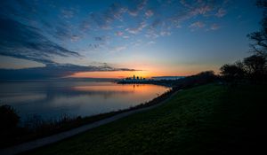 Preview wallpaper shore, water, horizon, buildings, sunset, dark