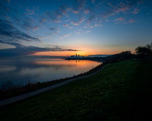 Preview wallpaper shore, water, horizon, buildings, sunset, dark