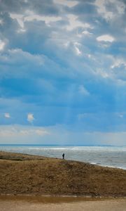 Preview wallpaper silhouette, alone, coast, sea, clouds, rays, light