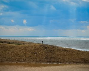 Preview wallpaper silhouette, alone, coast, sea, clouds, rays, light