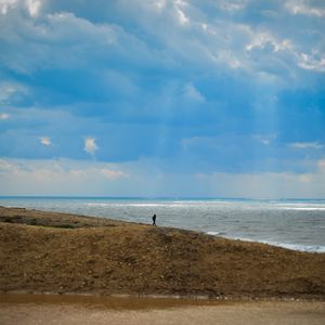 Preview wallpaper silhouette, alone, coast, sea, clouds, rays, light