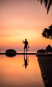 Preview wallpaper silhouette, alone, photographer, water, reflection, sunset, dark