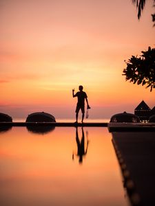 Preview wallpaper silhouette, alone, photographer, water, reflection, sunset, dark