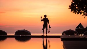 Preview wallpaper silhouette, alone, photographer, water, reflection, sunset, dark