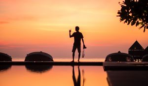 Preview wallpaper silhouette, alone, photographer, water, reflection, sunset, dark