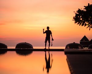 Preview wallpaper silhouette, alone, photographer, water, reflection, sunset, dark