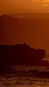 Preview wallpaper silhouette, alone, rock, sea, dusk