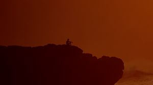 Preview wallpaper silhouette, alone, rock, sea, dusk