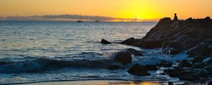 Preview wallpaper silhouette, alone, rocks, sea, horizon, sunset