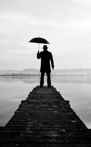 Preview wallpaper silhouette, alone, umbrella, hat, pier, water, black and white