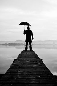 Preview wallpaper silhouette, alone, umbrella, hat, pier, water, black and white