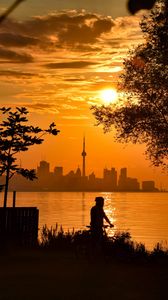 Preview wallpaper silhouette, city, buildings, sunset, sea