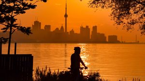 Preview wallpaper silhouette, city, buildings, sunset, sea