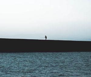 Preview wallpaper silhouette, coast, dark, sea, fisherman