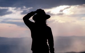 Preview wallpaper silhouette, hat, mountains, dark